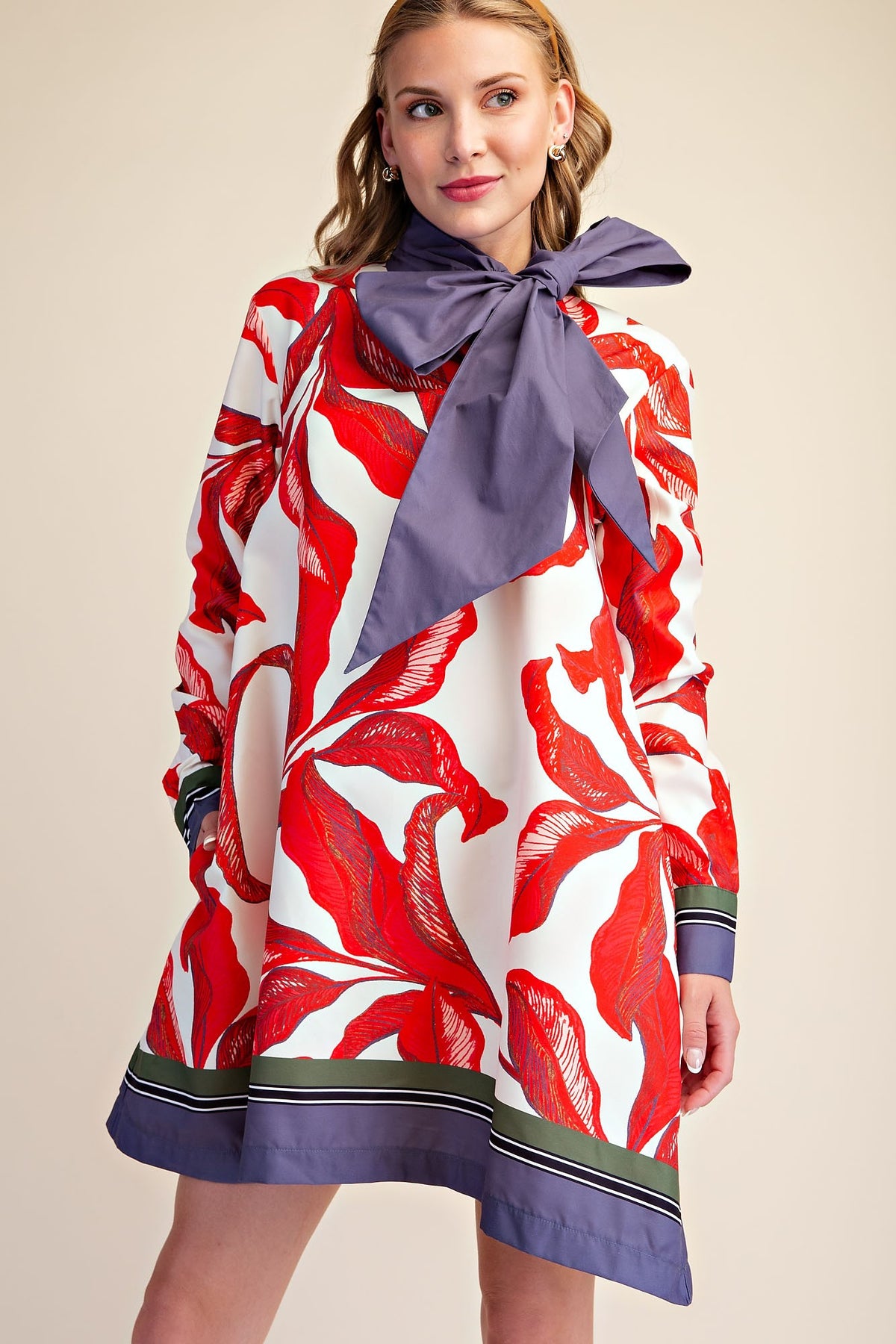 Vista frontal del vestido Musa Botánica con estampado rojo y lazo violeta